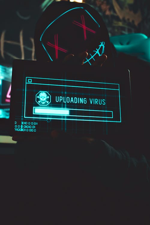 An image of a hacker holding a screen while uploading a virus