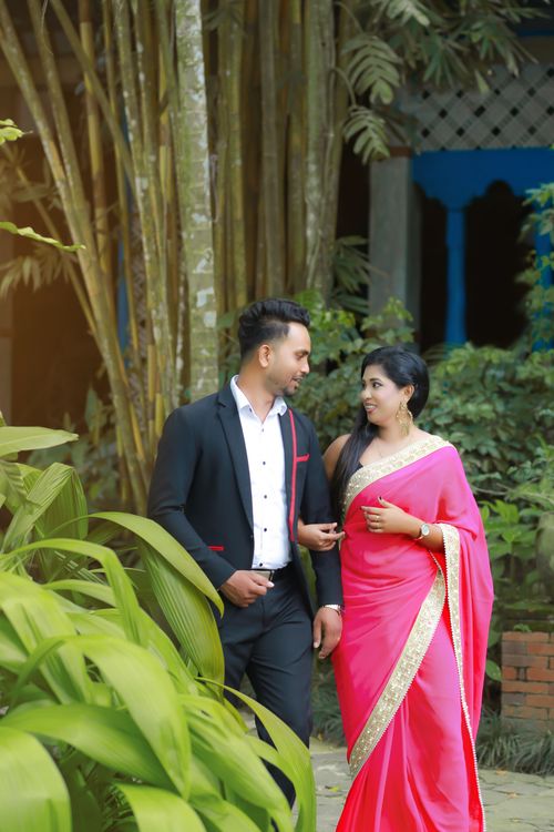 Free A couple walking outdoors, dressed in traditional attire, exuding elegance and charm. Stock Photo