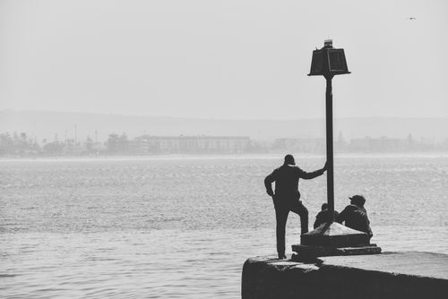 Free Silhouettes of people by the sea in Essaouira's foggy harbor, Morocco Stock Photo