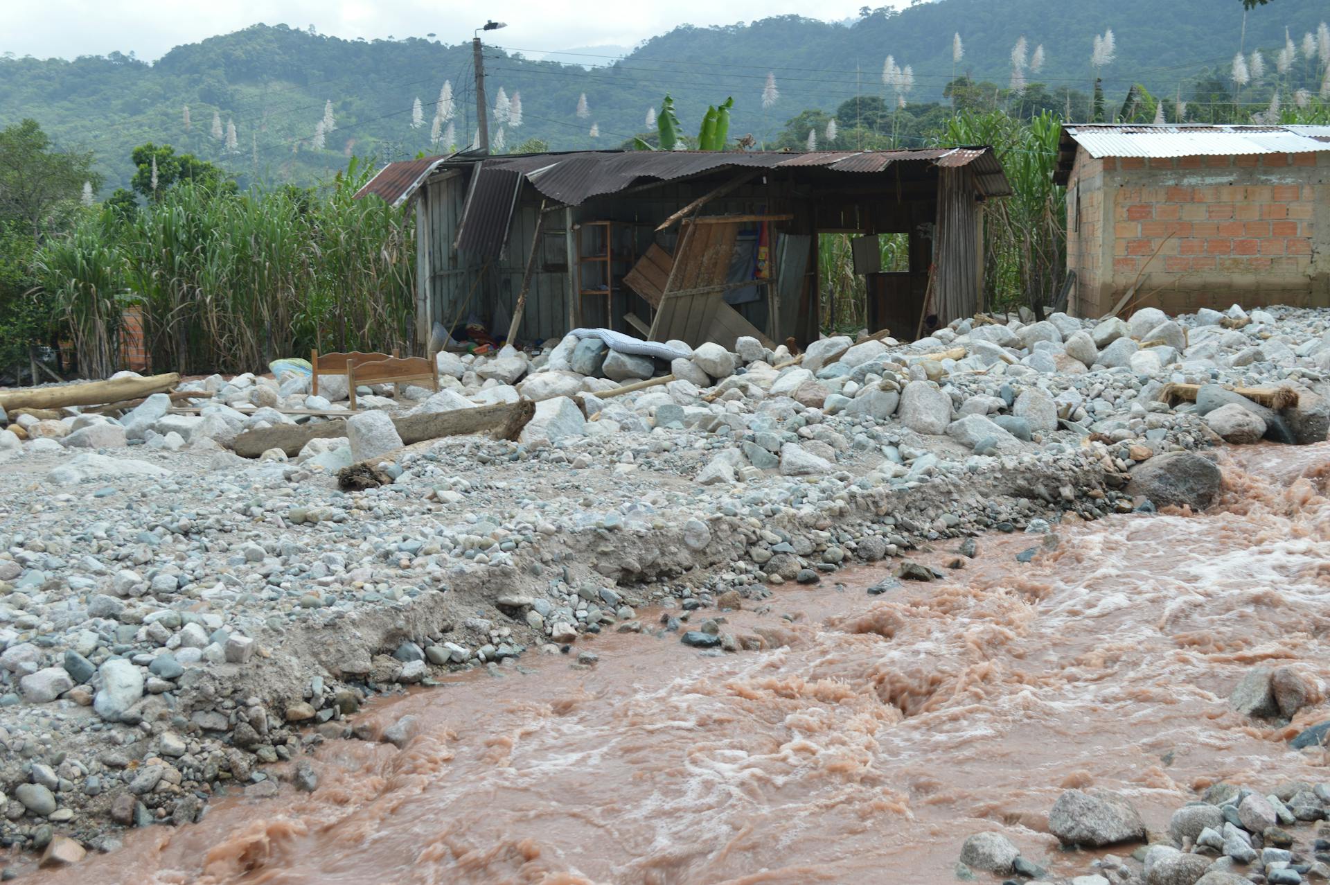 Severe flood damage to rural homes in Mocoa, Colombia, highlighting devastation and recovery needs.