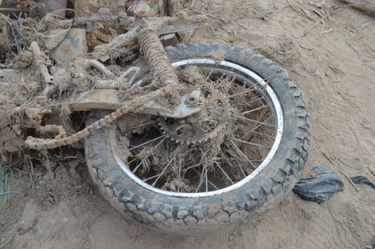Close-up of an abandoned motorcycle tire covered in mud, located in Mocoa, Colombia.
