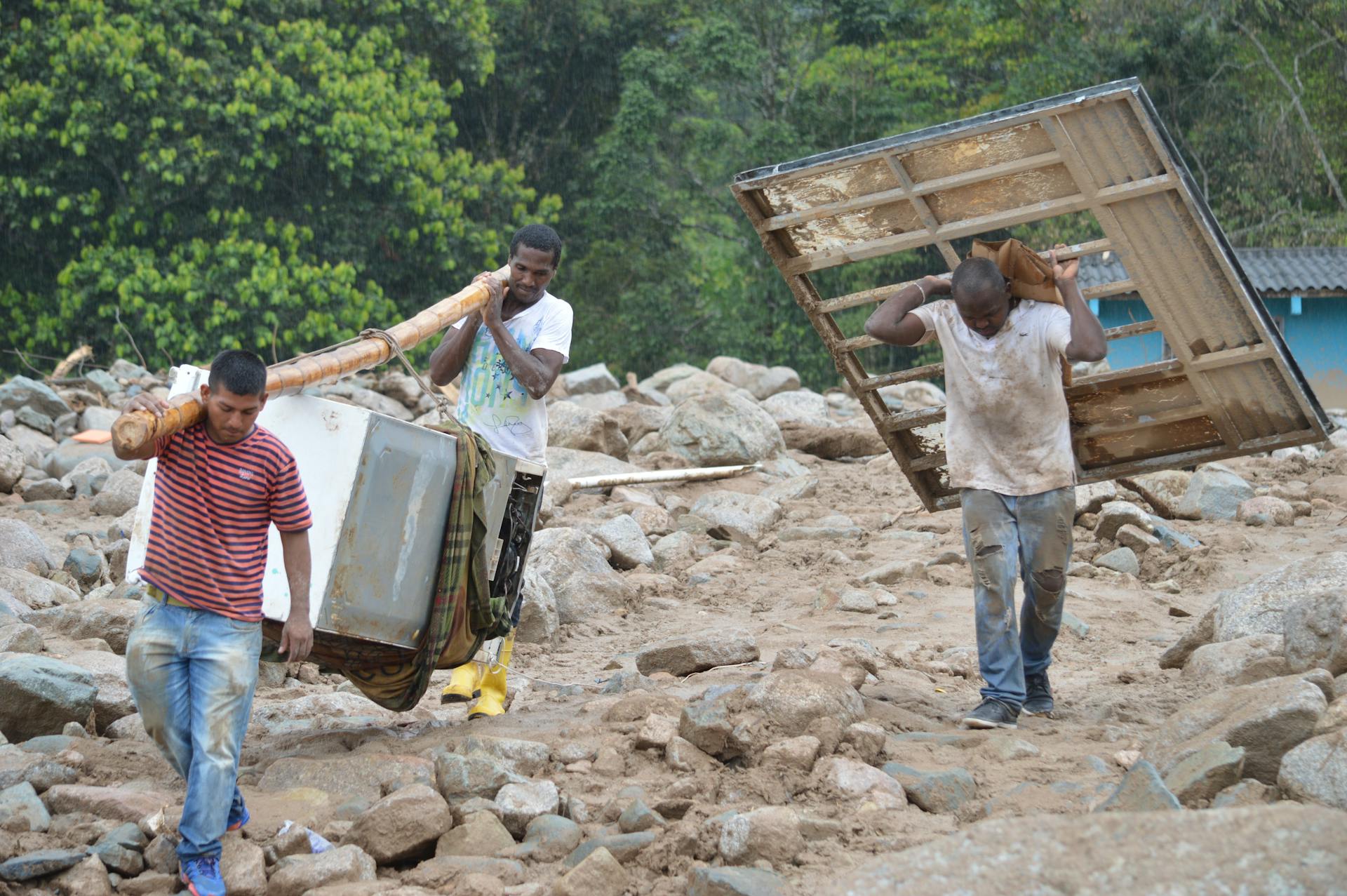 Men salvage belongings amidst the aftermath of the Mocoa landslide in Colombia.