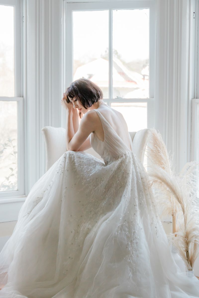 Bride in an ivory gown by a sunlit window