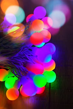 A close-up view of glowing multi-colored LED string lights with a defocused bokeh effect.