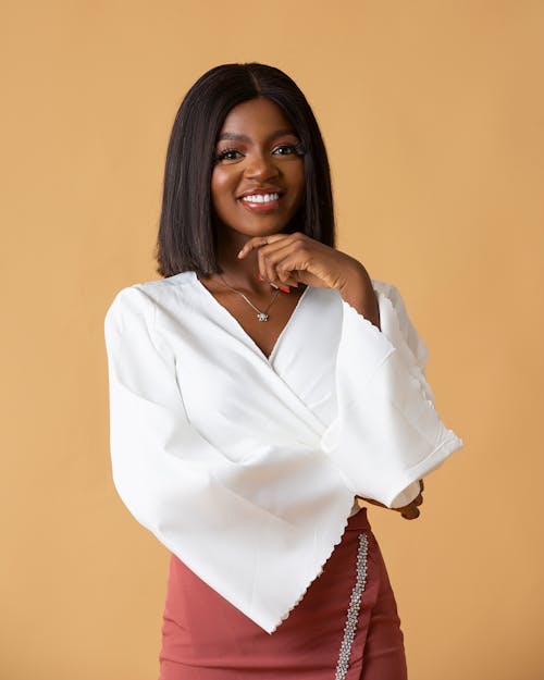 Woman Wearing White Blouse Posing against Beige Background