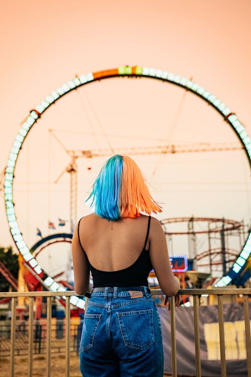 Back View of a Young Woman with Dyed Hair in an Amusement Park 
