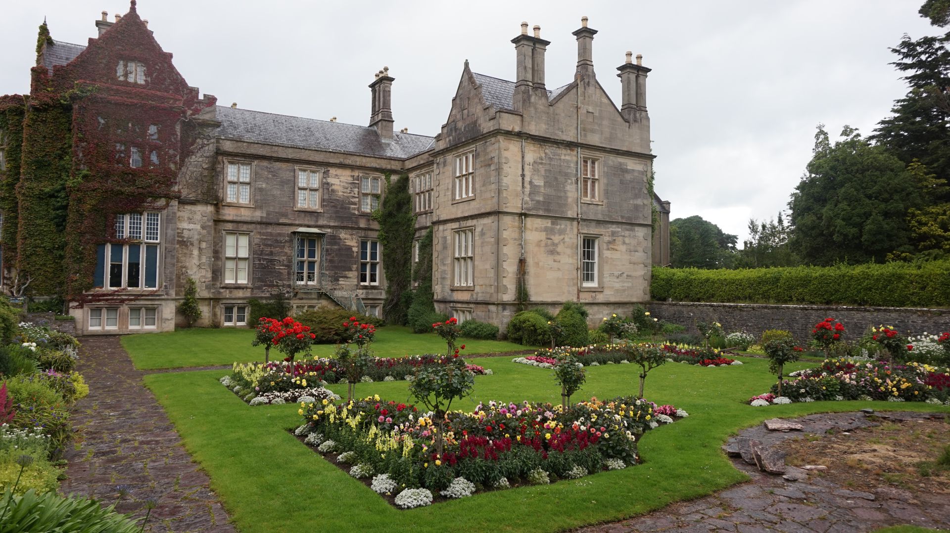 Green Red and Yellow Garden in Front of Gray Concrete House during Daytime