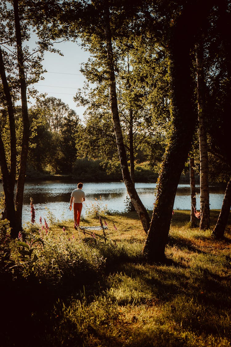 A Man Walking Near A Lake