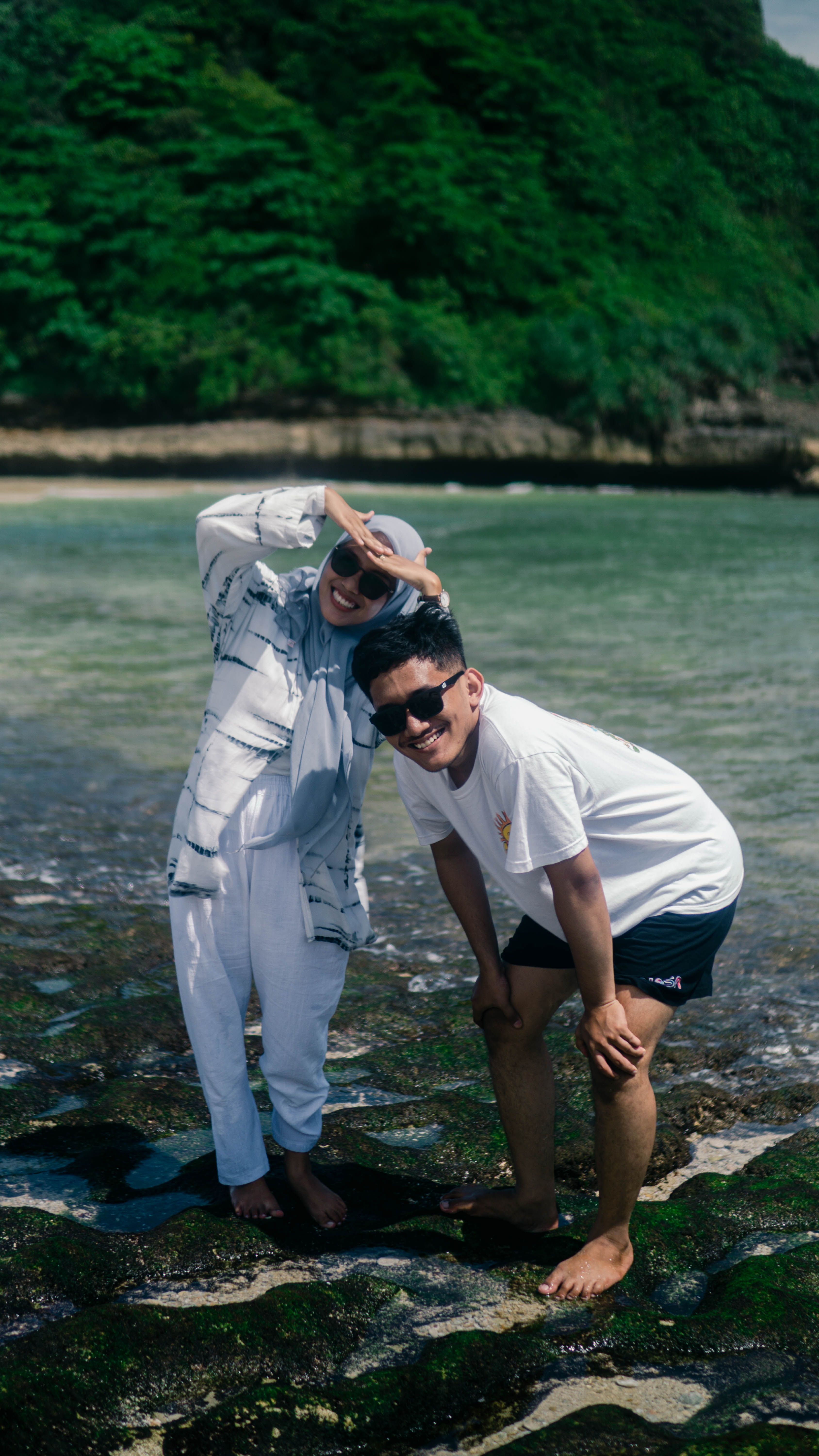 A joyful couple enjoying their vacation by the sea in Malang, Indonesia.