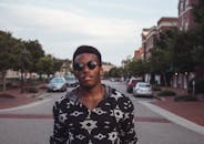 威廉斯堡的街道上，一个戴着墨镜的时尚男人自信地站着