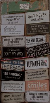 Collection of humorous and motivational quote signs displayed on a rustic wooden wall. — photo by Damir K .