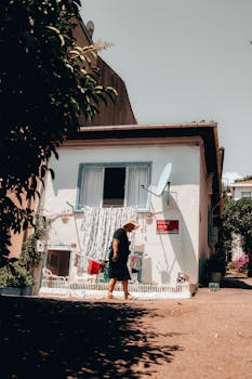 A woman walks past a typical Istanbul house on a sunny day.