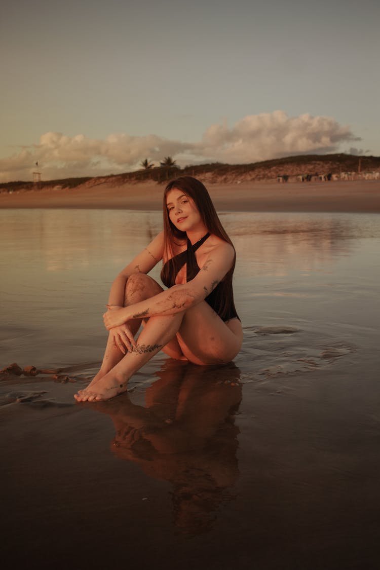 Girl Wearing Black Swimsuit Posing In A Mud