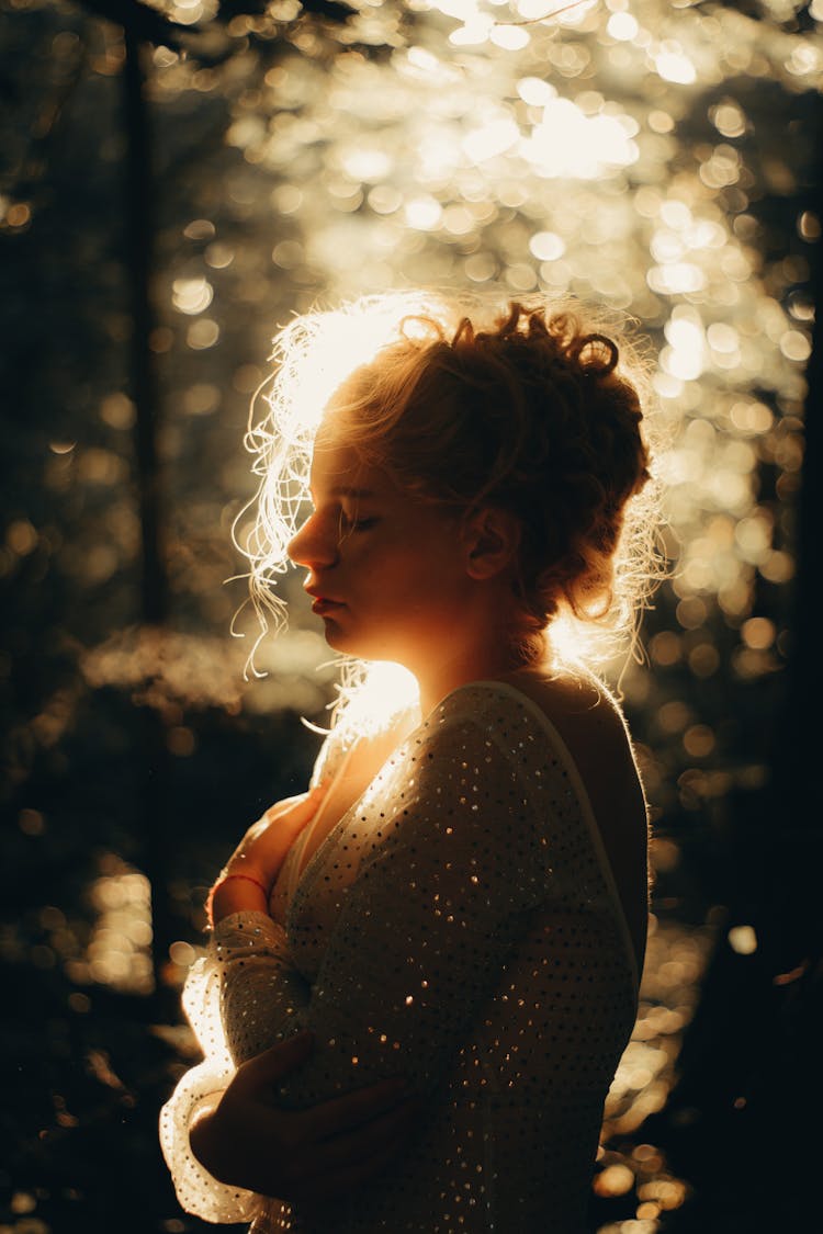 Back Lit Profile Of A Girl Wearing A Vintage Dress In A Park