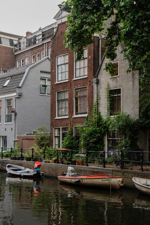 Boats Docked on Side of a Canal 