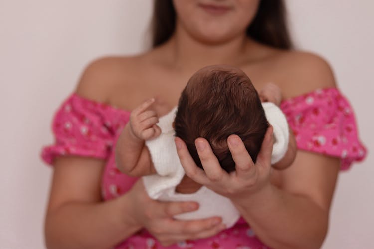 A Person Holding A Newborn Baby 