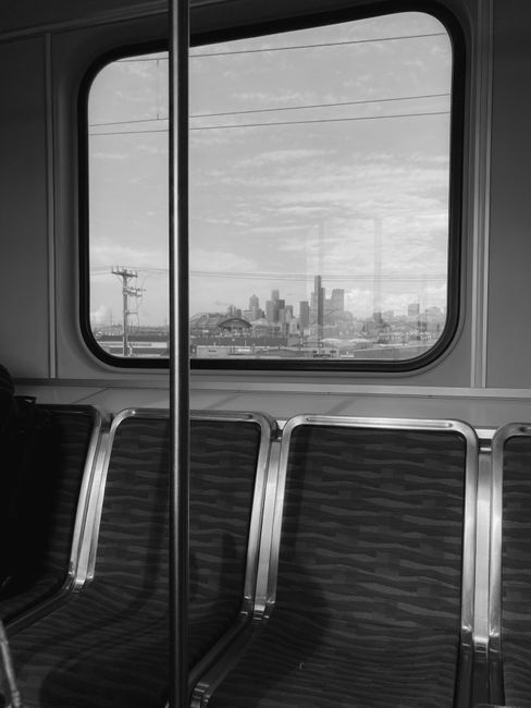 Monochrome view of Seattle skyline from train window, capturing urban travel vibe.
