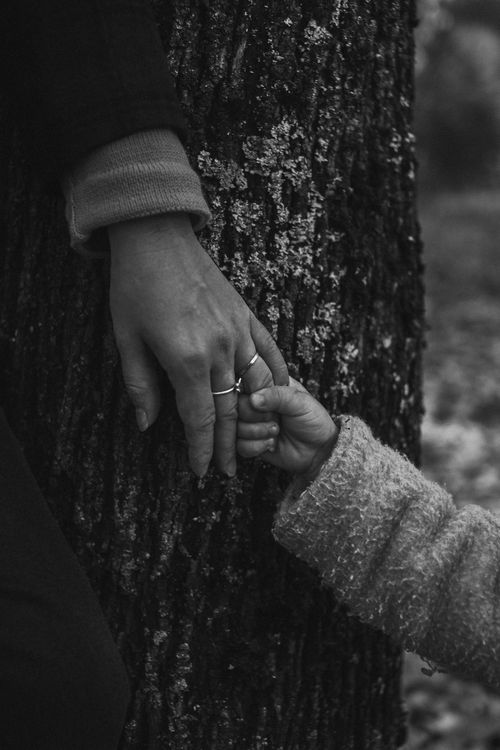 Free Black and white photo of a mother and child holding hands, symbolizing love and trust. Stock Photo