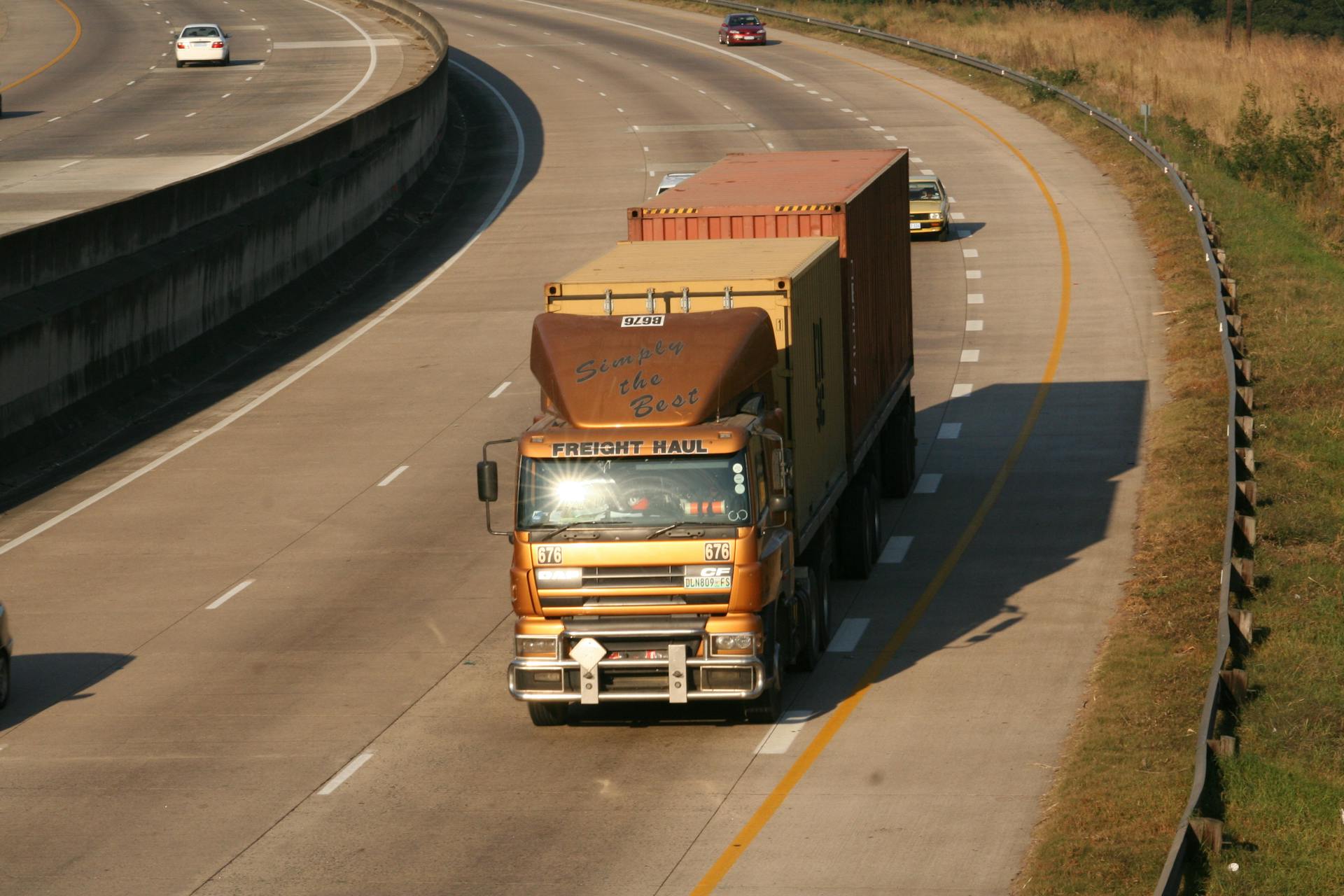 Cargo truck navigating a highway, aerial view on Dolphin Coast, South Africa.