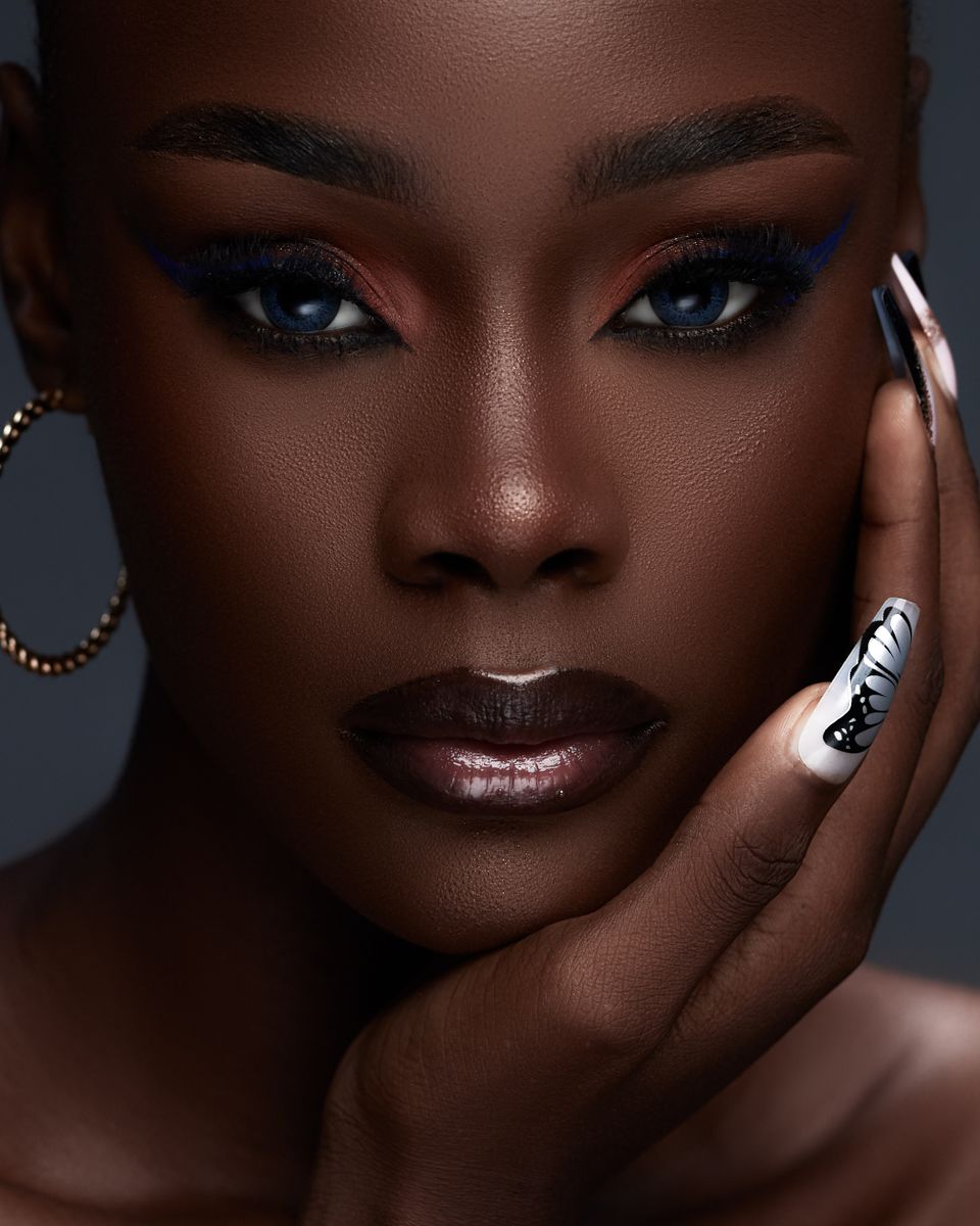Beautiful close-up portrait showcasing bold eye makeup and fashion nail art.