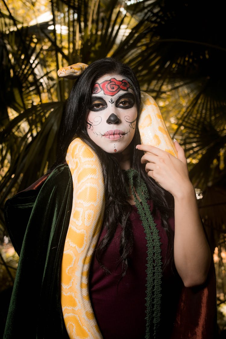 Woman With Death Mask Holding A Yellow Snake