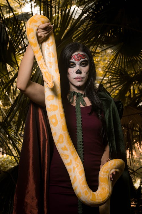 Woman with Face Paint Holding a Snake