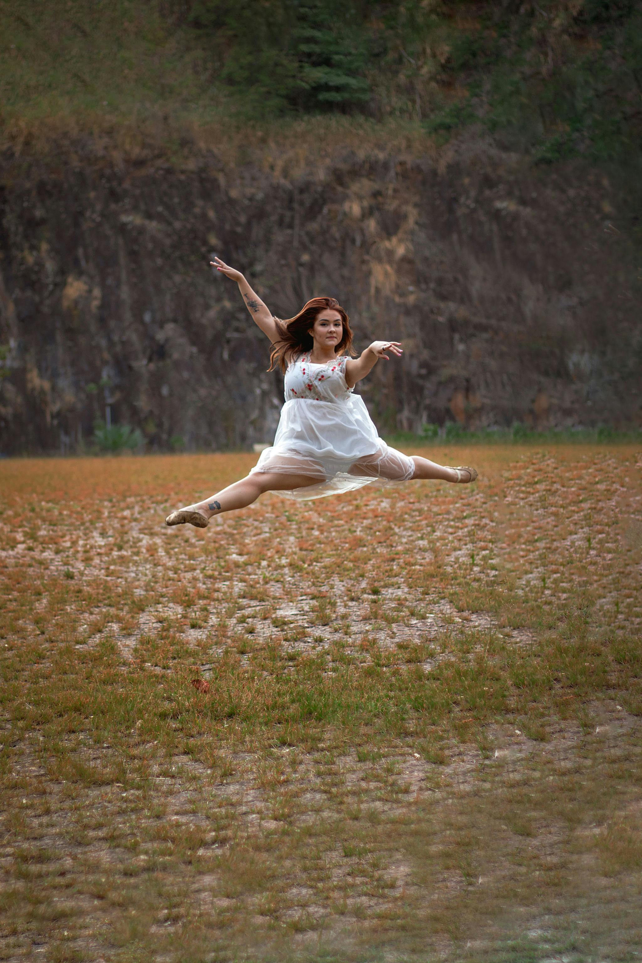 girl doing splits in the air on a field