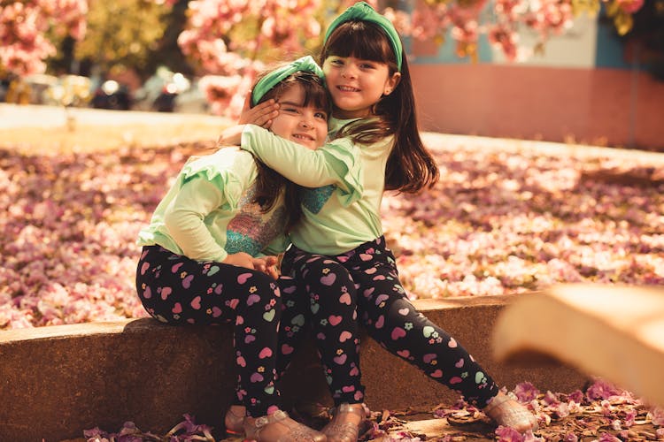 Pretty Little Girls Sitting On A Gutter