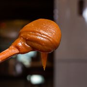 Caramel sauce dripping from a wooden spoon — Vinícius Caricatte on Pexels