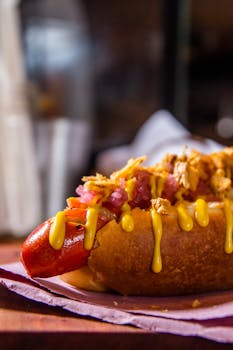 Delicious gourmet hot dog topped with mustard and crispy onions, perfect for a quick bite.