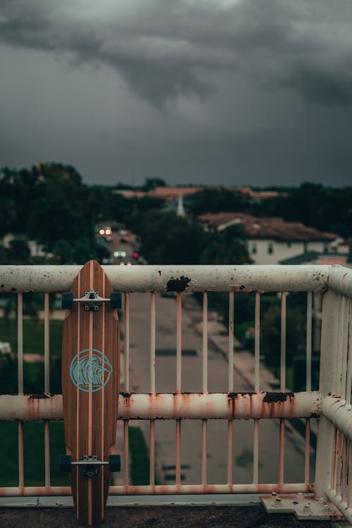 A Longboard Leaning on Rusty Metal Railing