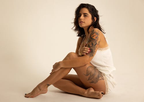 Woman with Body Tattoo Sitting on the Floor