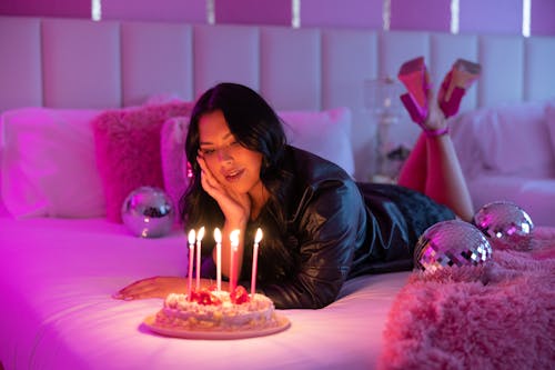 Free Woman Lying on the Bed with Birthday Cake  Stock Photo