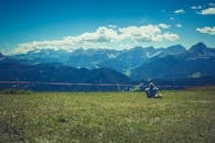 徒步旅行者在明亮的夏日天空下，欣赏着风景优美的山脉的宁静场景