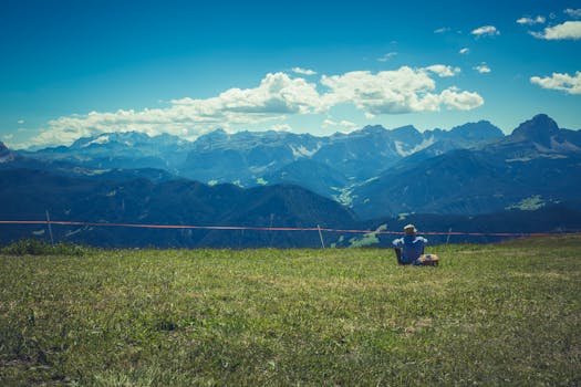 徒步旅行者在明亮的夏日天空下，欣赏着风景优美的山脉的宁静场景