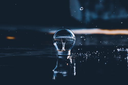 Photograph of a Light Bulb Near Water Splash