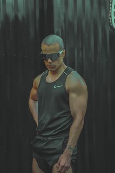 A stylish man in activewear poses outdoors in Mexico City, exuding confidence.