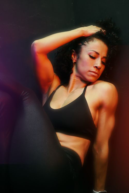Free Muscular woman posing indoors, wearing black sportswear, exuding strength and confidence. Stock Photo
