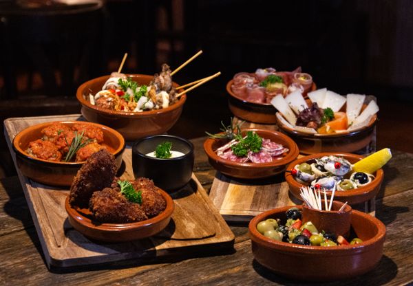 Wooden board of small sharing plates — photo by Bas Linders on Pexels