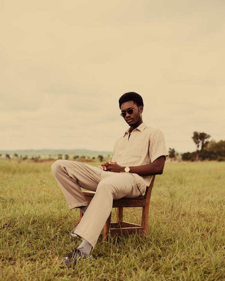 Stylish Man Sitting On Chair In Field