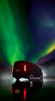 Van parked under a stunning aurora borealis with starry night sky reflection on a frozen lake.