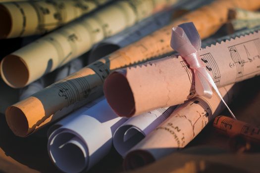 Close-up of rolled music sheets tied with ribbon, perfect for creative and artistic projects.