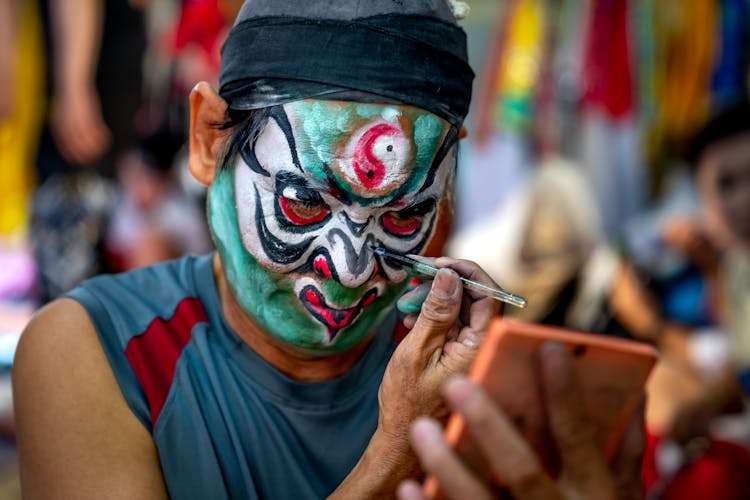 Man Applying Paint On His Face