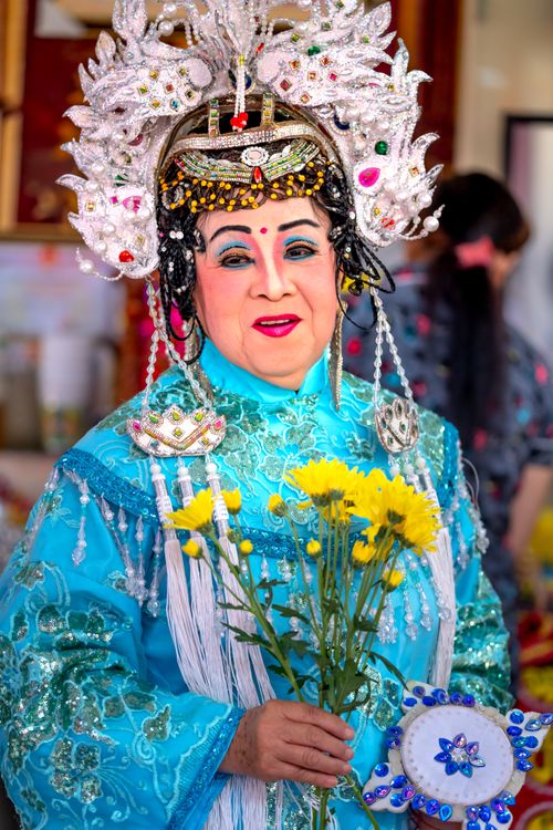 Free Chinese performer in traditional costume holding flowers, displaying cultural heritage. Stock Photo