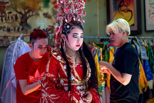 Free A performer prepares for a traditional Asian festival with intricate makeup and costume. Stock Photo