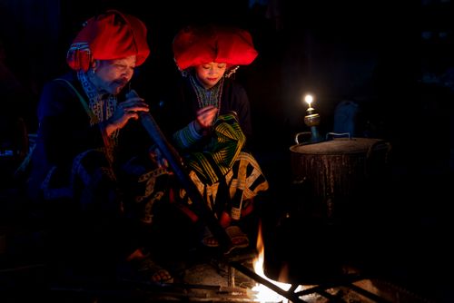 Free Two women in traditional attire by a fireplace, creating a warm, cultural scene. Stock Photo