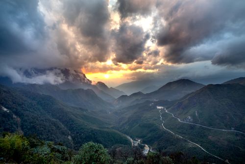 Free Dramatic sunset over lush green mountains with a cloudy sky, captured from above. Stock Photo
