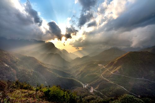 Free Breathtaking sunrise over a scenic mountain range with dramatic clouds and rays of light. Stock Photo