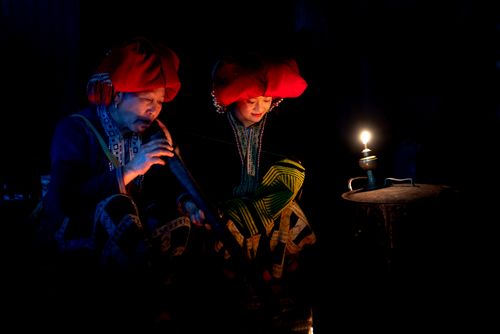 Free A couple in traditional clothes illuminated by lamp, showcasing cultural heritage and intimacy. Stock Photo