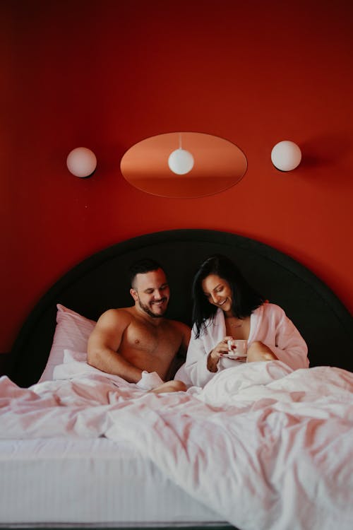 A Couple Relaxing Comfortably in Bed